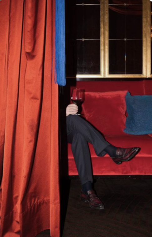 A glass of red in a velvet booth